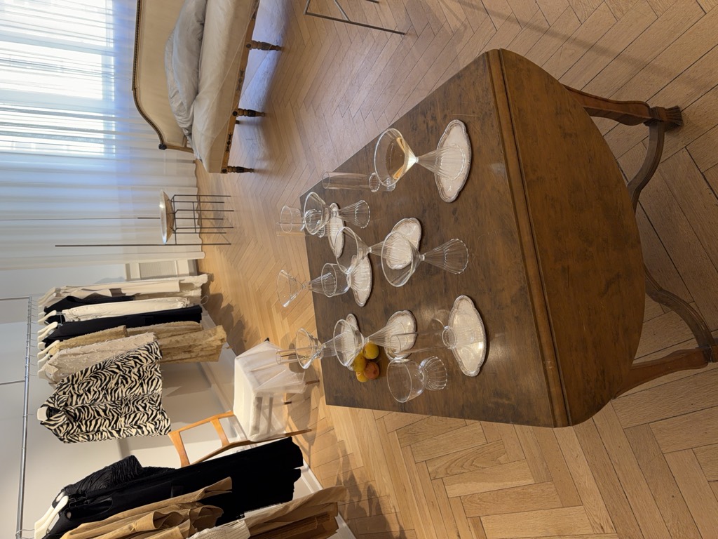 Glasses set out on a wooden table in a sunlit showroom.